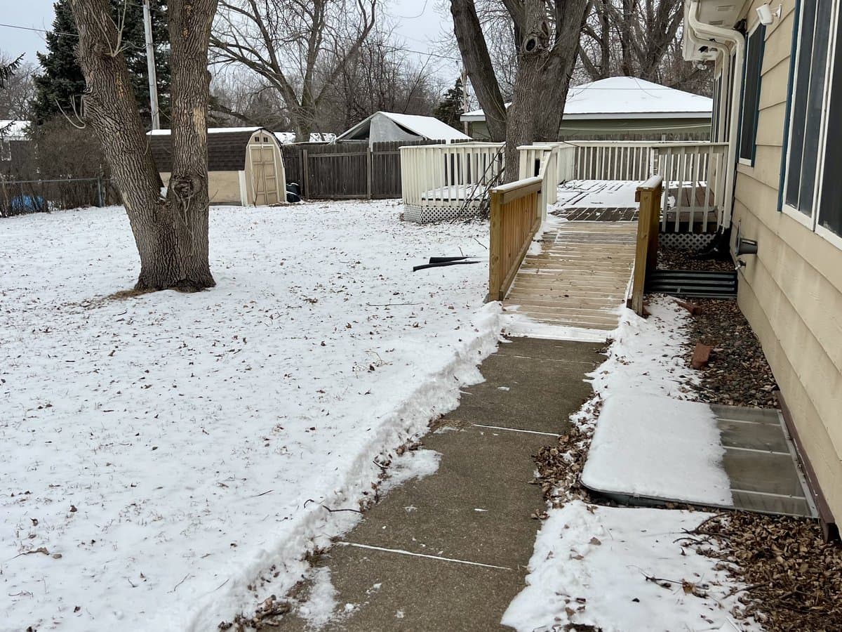 Side walkway leading to an accessible wooden ramp and back deck